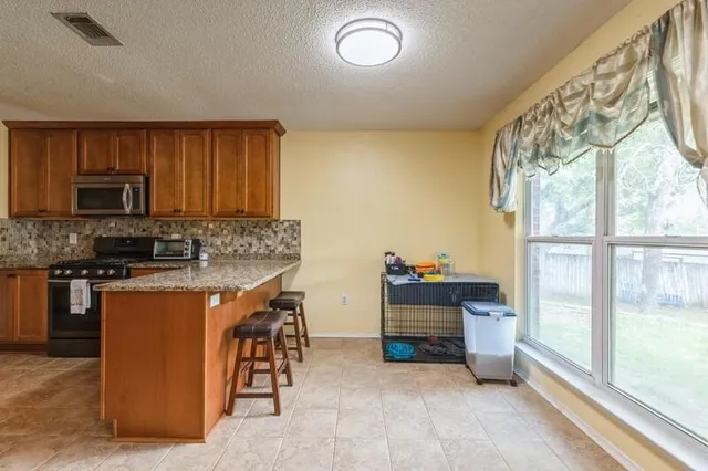 a kitchen with stainless steel appliances granite countertop a stove and a sink