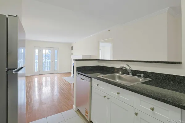 a view of an empty room with glass door and wooden floor