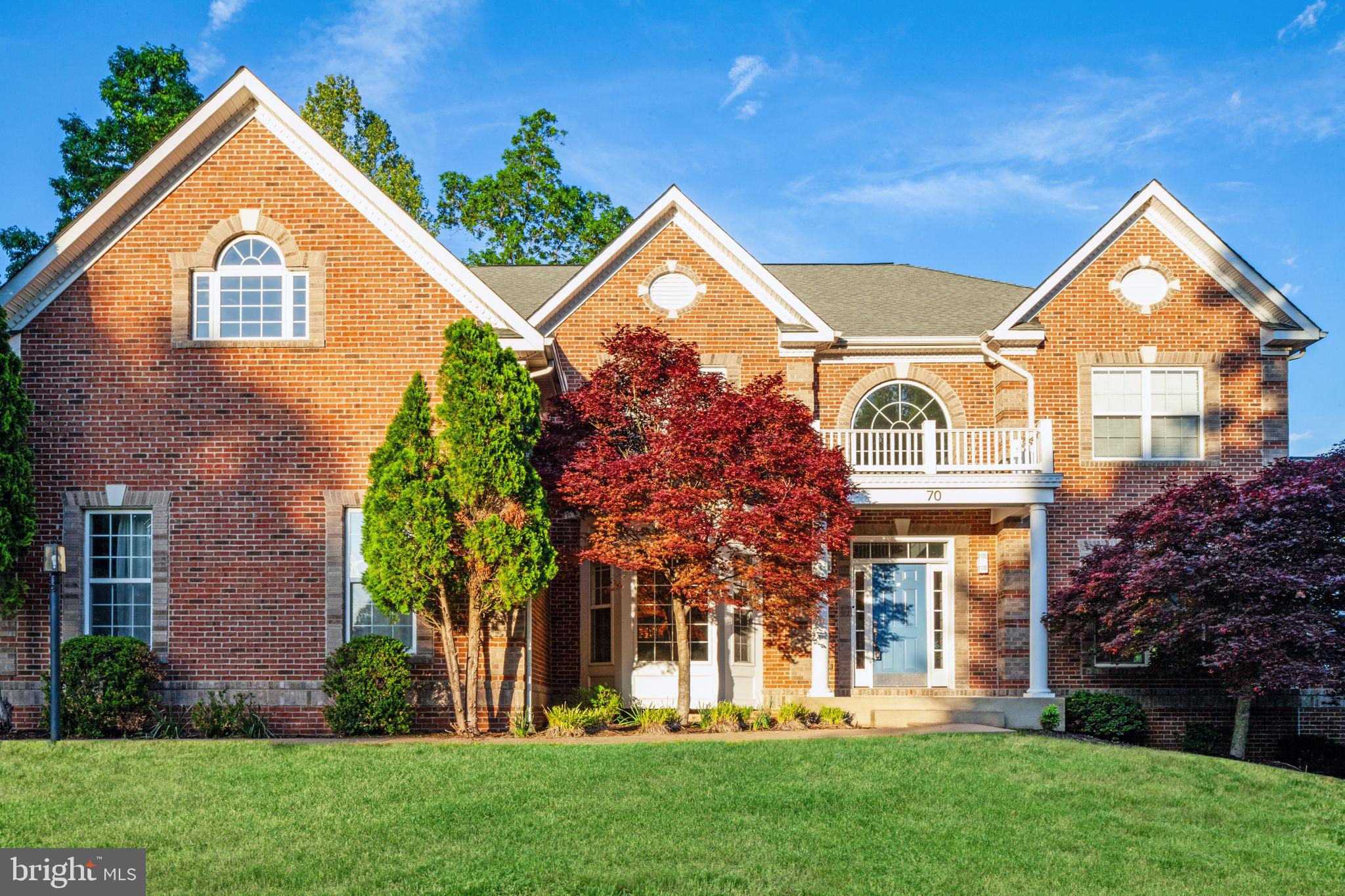 front view of house with a yard and potted plants