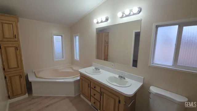 a bathroom with a sink double vanity mirror and a toilet