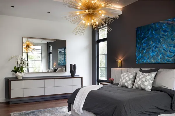 a bedroom with a large bed and a chandelier