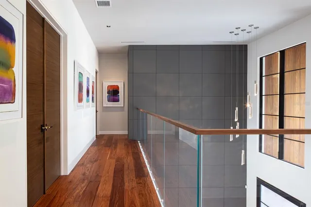a view of a hallway with wooden floor and staircase