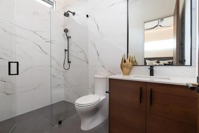 a bathroom with a sink a toilet and shower