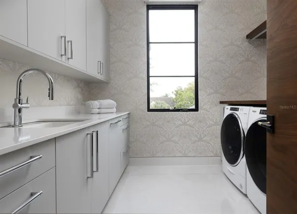 a utility room with sink dryer and washer
