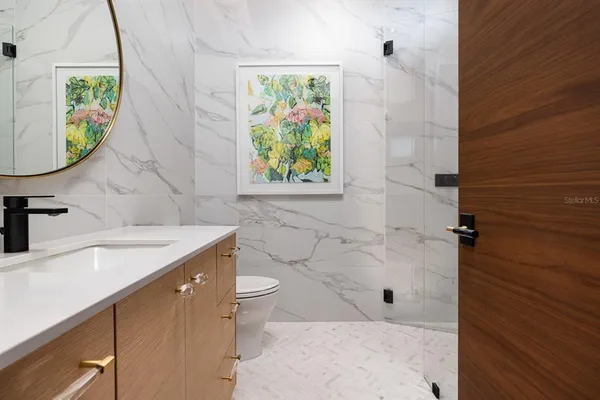 a bathroom with a granite countertop sink a toilet and a shower