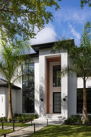 a front view of a house with a yard garage and tree