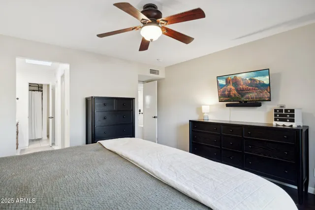 a bedroom with a bed chandelier and a window