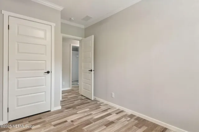 a view of a hallway with wooden floor and closet