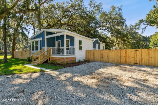 a front view of a house with a yard and trees