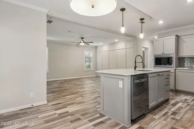 a kitchen with kitchen island a sink stainless steel appliances and cabinets