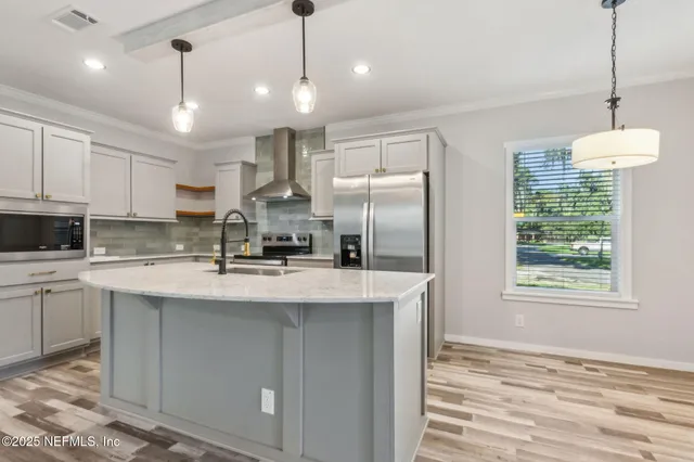 a kitchen with stainless steel appliances granite countertop a sink a refrigerator a stove a kitchen island with a stove and refrigerator