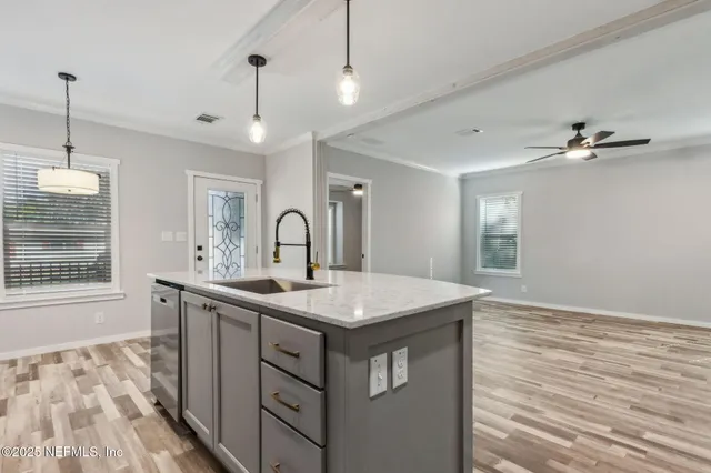 a kitchen with a sink a window and wooden floor