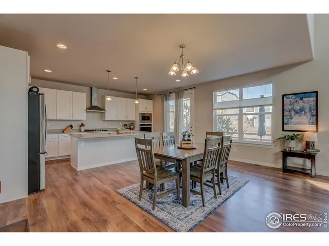 a view of a dining room and livingroom with furniture wooden floor a chandelier