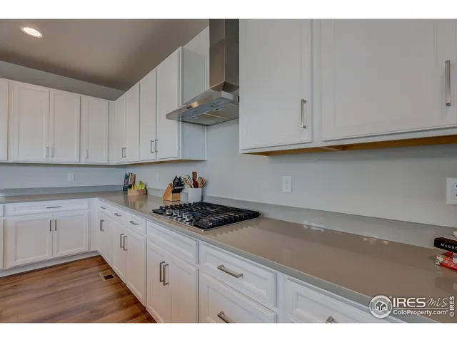 a kitchen with granite countertop white cabinets and sink