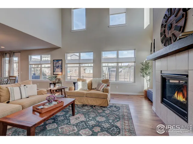 a living room with furniture a fireplace and a large window