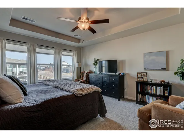 a bedroom with a bed a window and a flat screen television