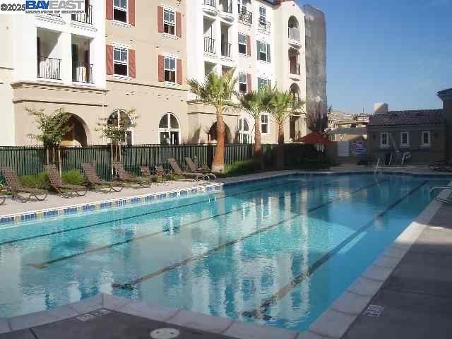 a building view with swimming pool and large trees