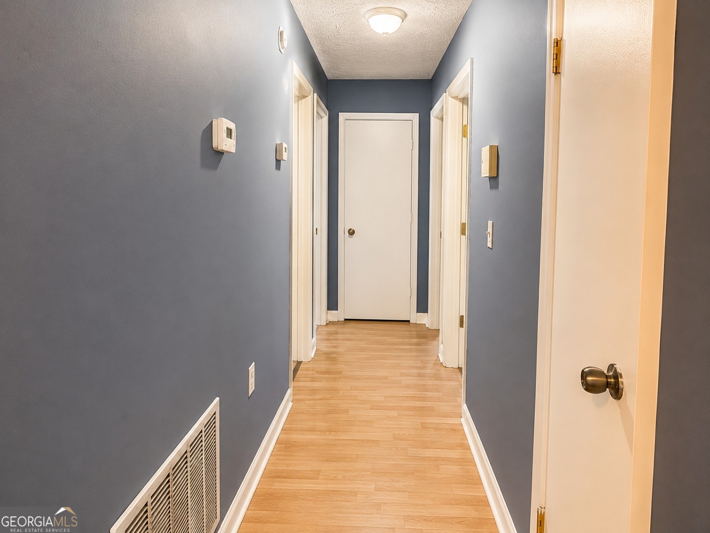 7055 Swift Street Lithonia, GA 30058 - Photo 6 of 9 a view of a hallway with wooden floor and a bathroom