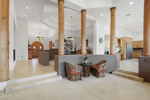 a living room with furniture a table and kitchen view