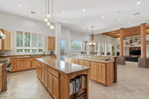 a large kitchen with kitchen island a sink a center island a stove a dining table and chairs