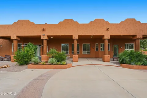 a front view of a house with a yard and mountain view