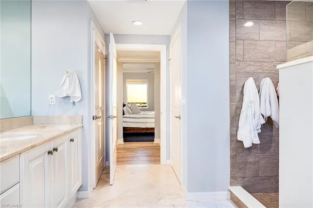 a en suite bathroom with a granite countertop sink and a mirror