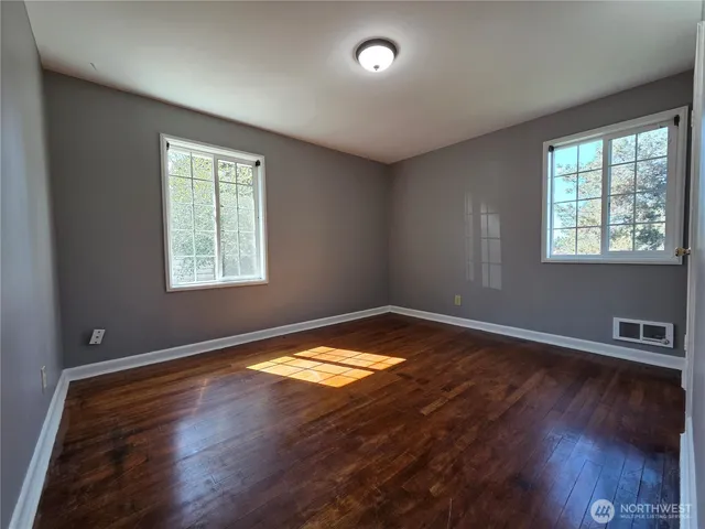 a kitchen with wooden floors and stainless steel appliances