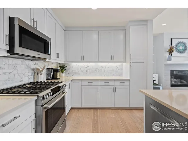 a kitchen with granite countertop a sink stove and microwave