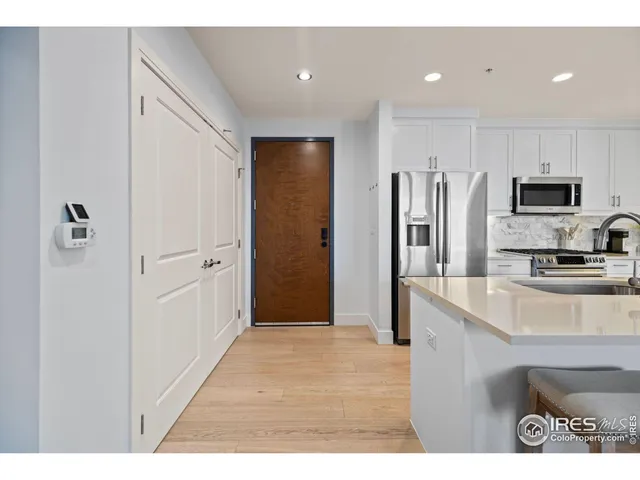 a kitchen with stainless steel appliances granite countertop a refrigerator and a sink