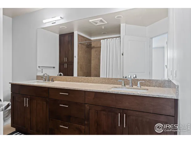 a bathroom with a granite countertop sink double vanity and a mirror