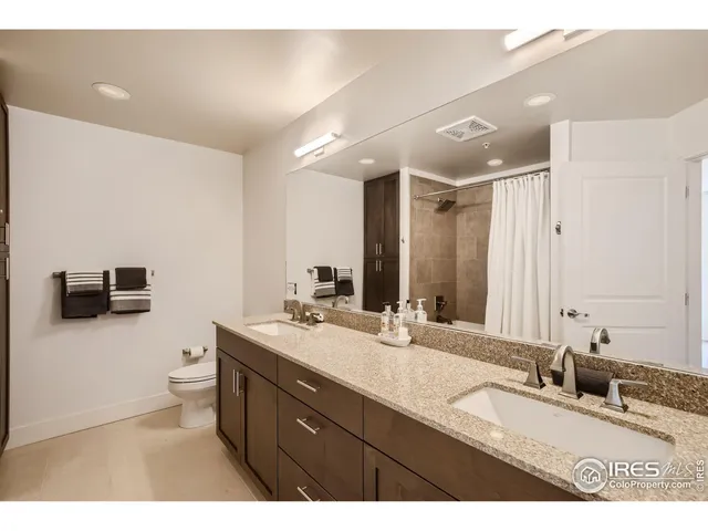 a bathroom with a granite countertop sink a toilet and a mirror