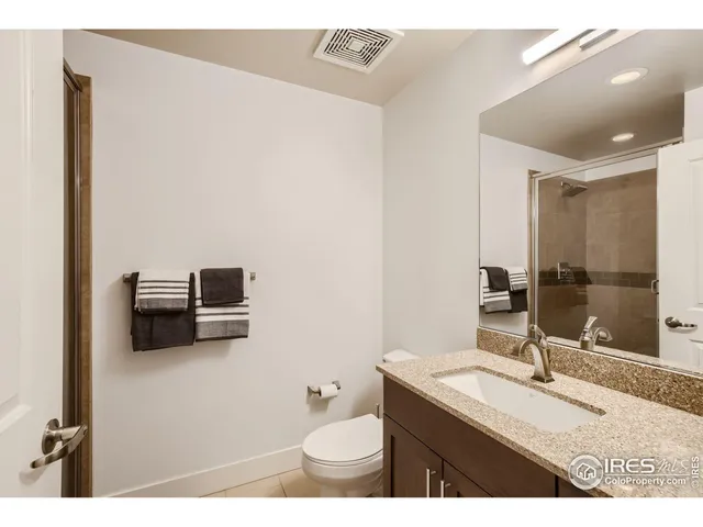 a bathroom with a sink a toilet a mirror and shower