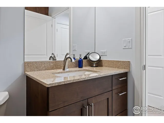 a bathroom with a granite countertop sink a toilet and a mirror