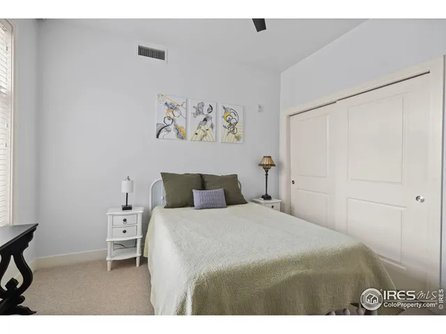 a bedroom with a bed and a painting on the wall