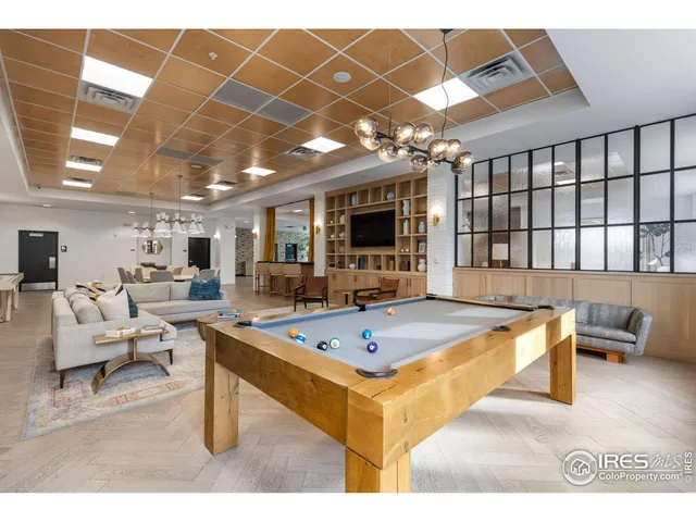 a living room with furniture a flat screen tv and a table