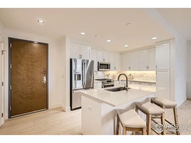 a kitchen with stainless steel appliances kitchen island granite countertop a refrigerator and a stove top oven