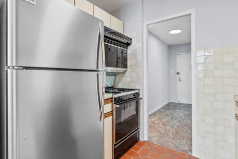 a kitchen with a refrigerator and a stove top oven
