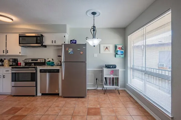 a kitchen with a refrigerator and a stove top oven