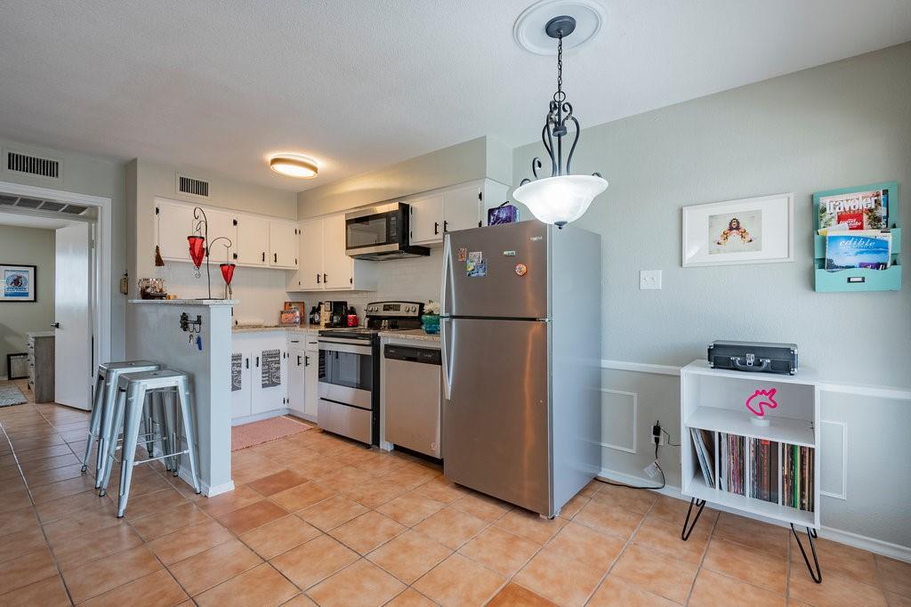 5000 Bowser Avenue, Unit 211 Dallas, TX 75209 - Photo 7 of 17 a kitchen with kitchen island a counter top space cabinets and stainless steel appliances