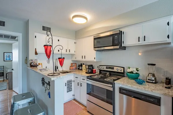 a kitchen with stainless steel appliances granite countertop a sink stove and microwave