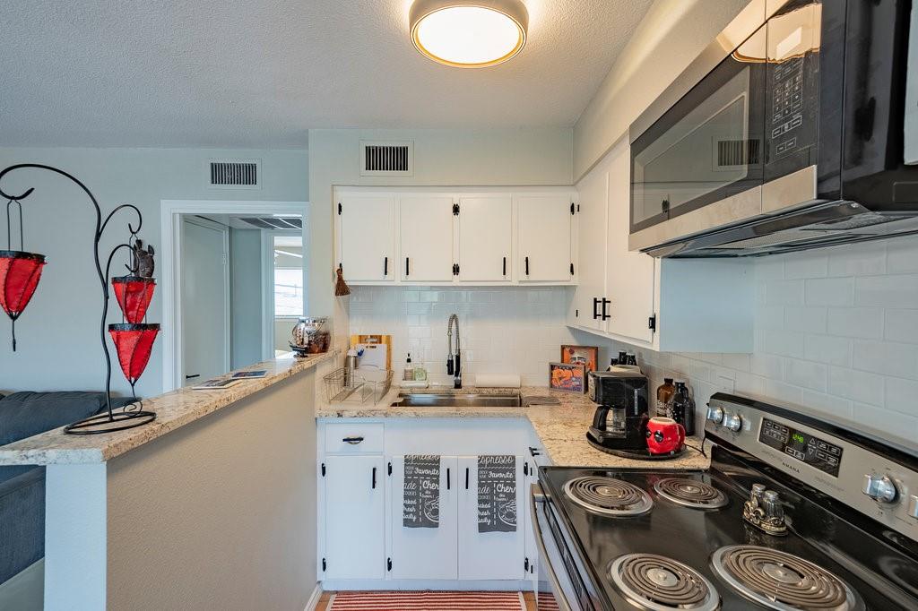 5000 Bowser Avenue, Unit 211 Dallas, TX 75209 - Photo 9 of 17 a kitchen with stainless steel appliances granite countertop a stove and a sink