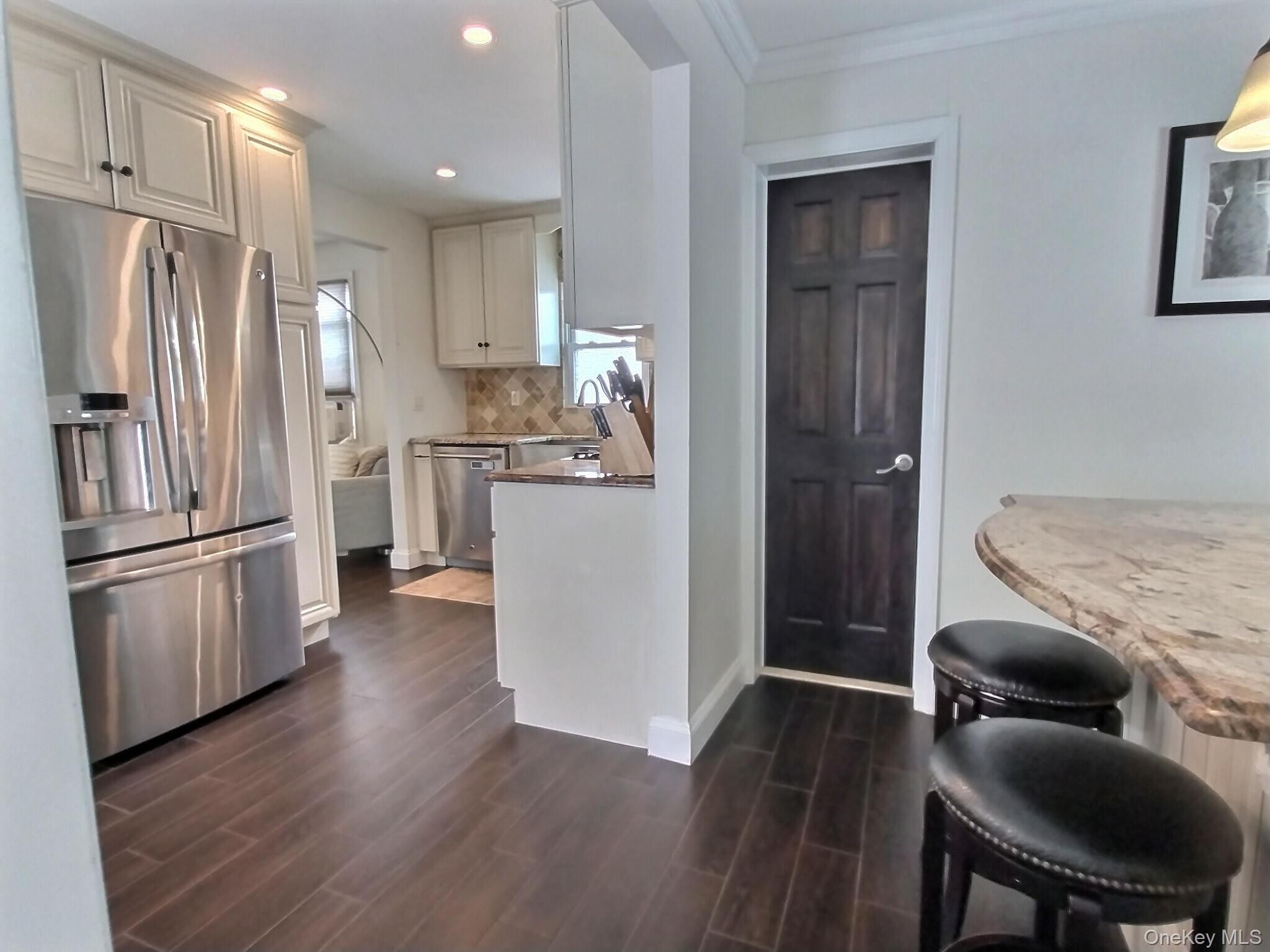 3037 Morrow Road Oceanside, NY 11572 - Photo 17 of 38 a kitchen with kitchen island wooden floors appliances and refrigerator