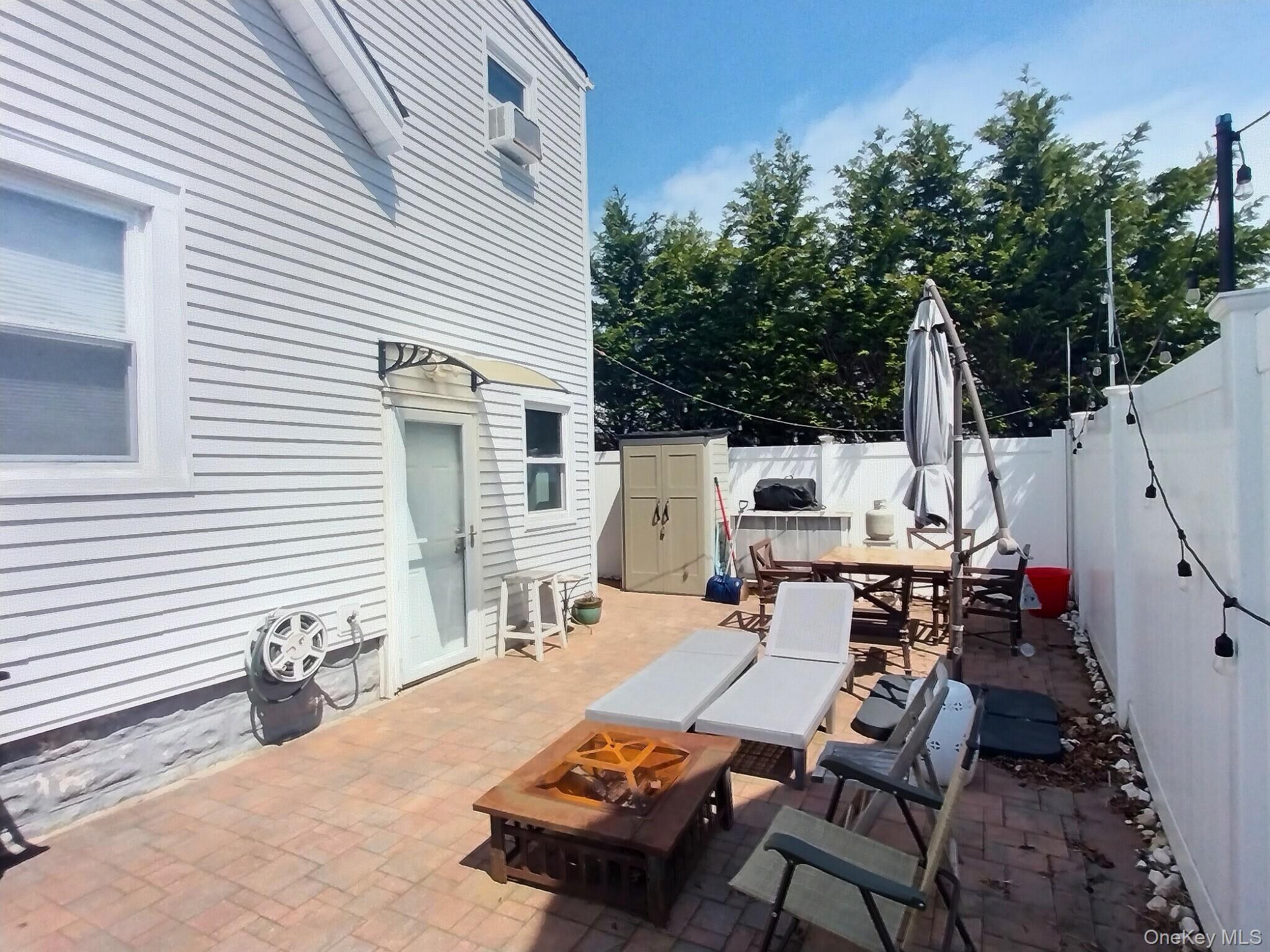 3037 Morrow Road Oceanside, NY 11572 - Photo 37 of 38 a view of a patio with table and chairs with wooden floor and fence