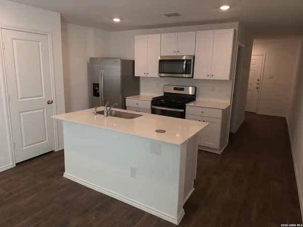 a kitchen with stainless steel appliances a refrigerator and a stove top oven