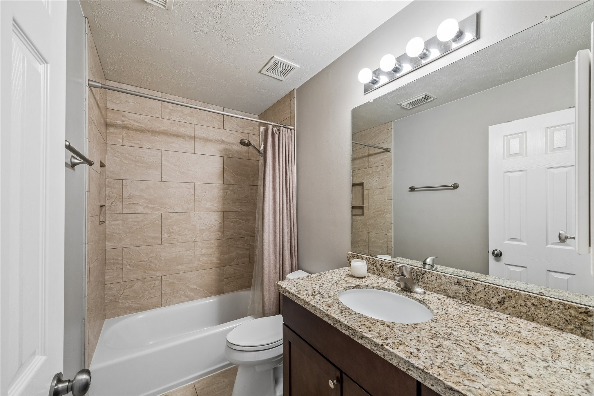 5811 Walkabout Way Katy, TX 77450 - Photo 22 of 33 Secondary bathroom with granite countertops and tiled tub/shower surround.