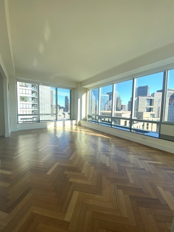 a view of an empty room with a floor to ceiling window and an empty room