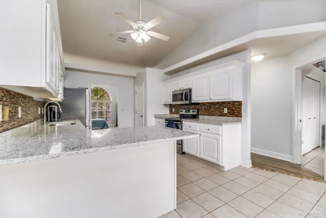 a kitchen with a refrigerator and a stove top oven