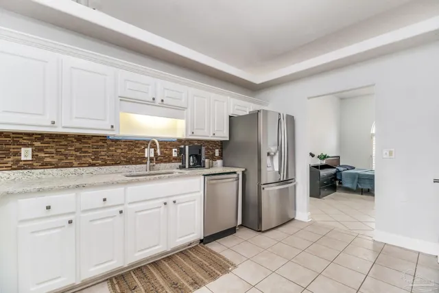 a kitchen with white cabinets and appliances