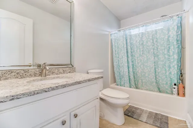 a bathroom with a granite countertop sink toilet and mirror