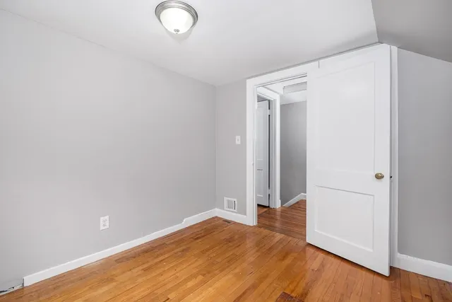 an empty room with wooden floor and closet